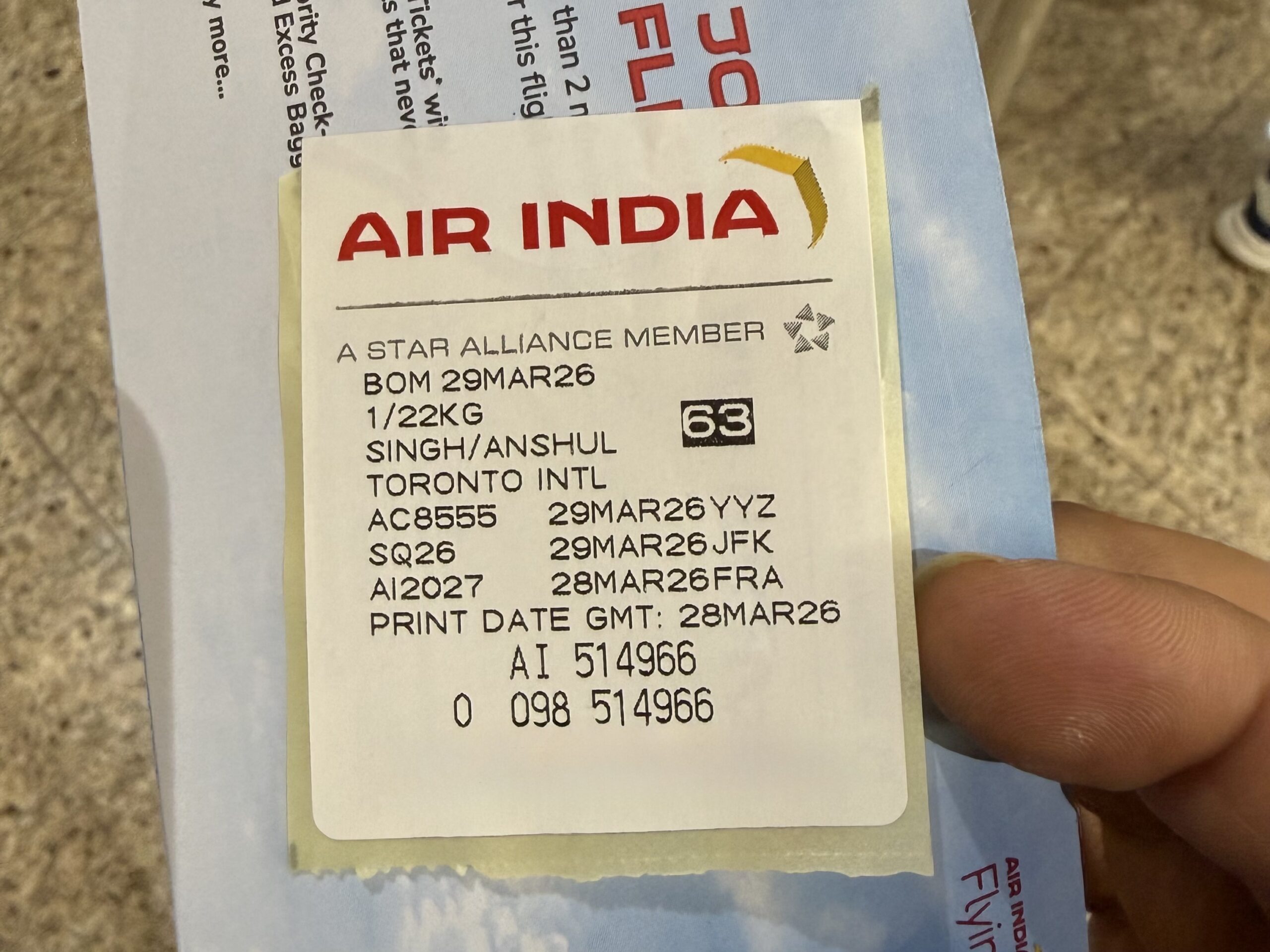 Air India 787-9 Business Class a hand holding a piece of paper with text and numbers