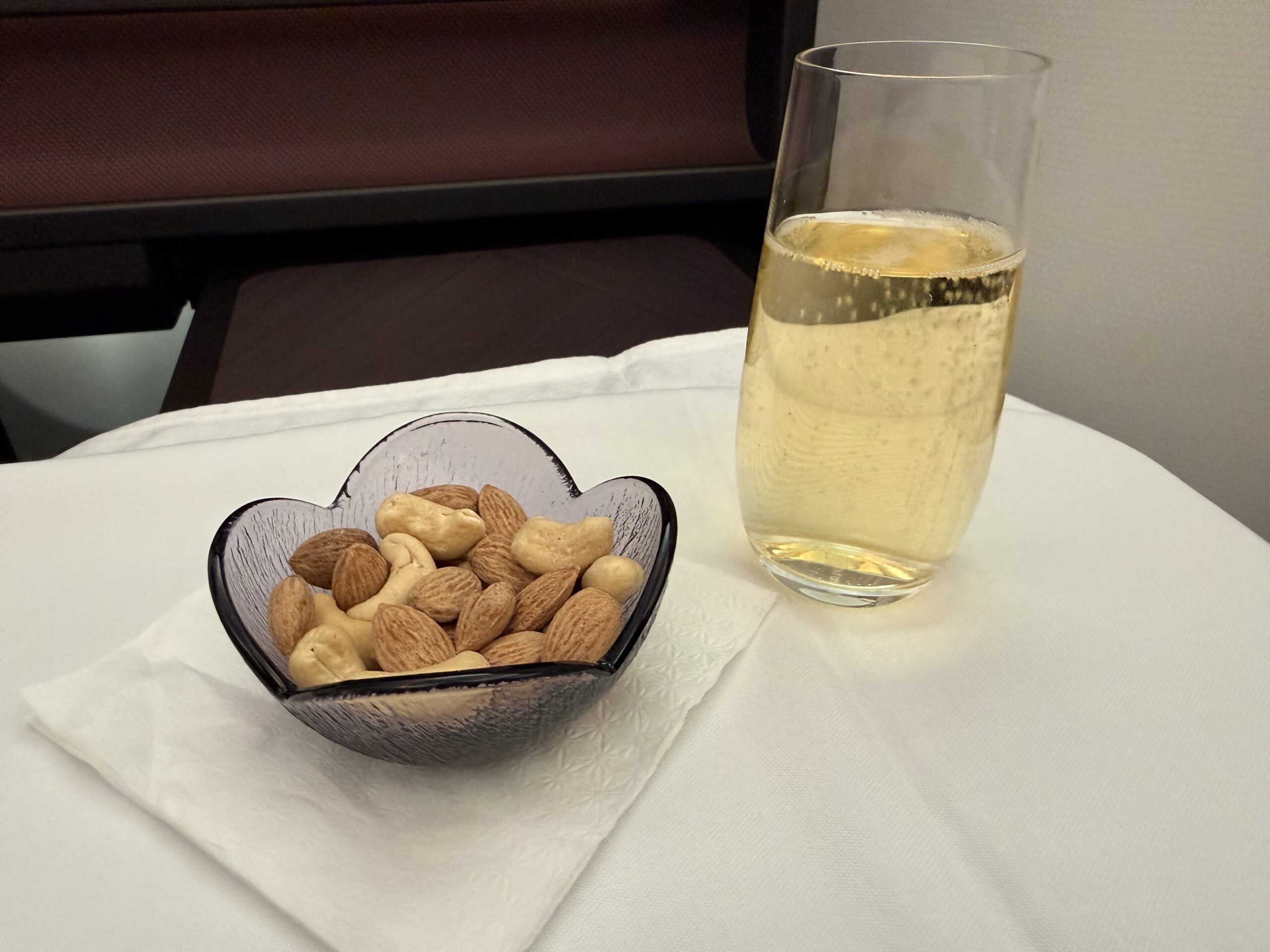 Air India 787-9 Business Class a bowl of nuts and a glass of champagne