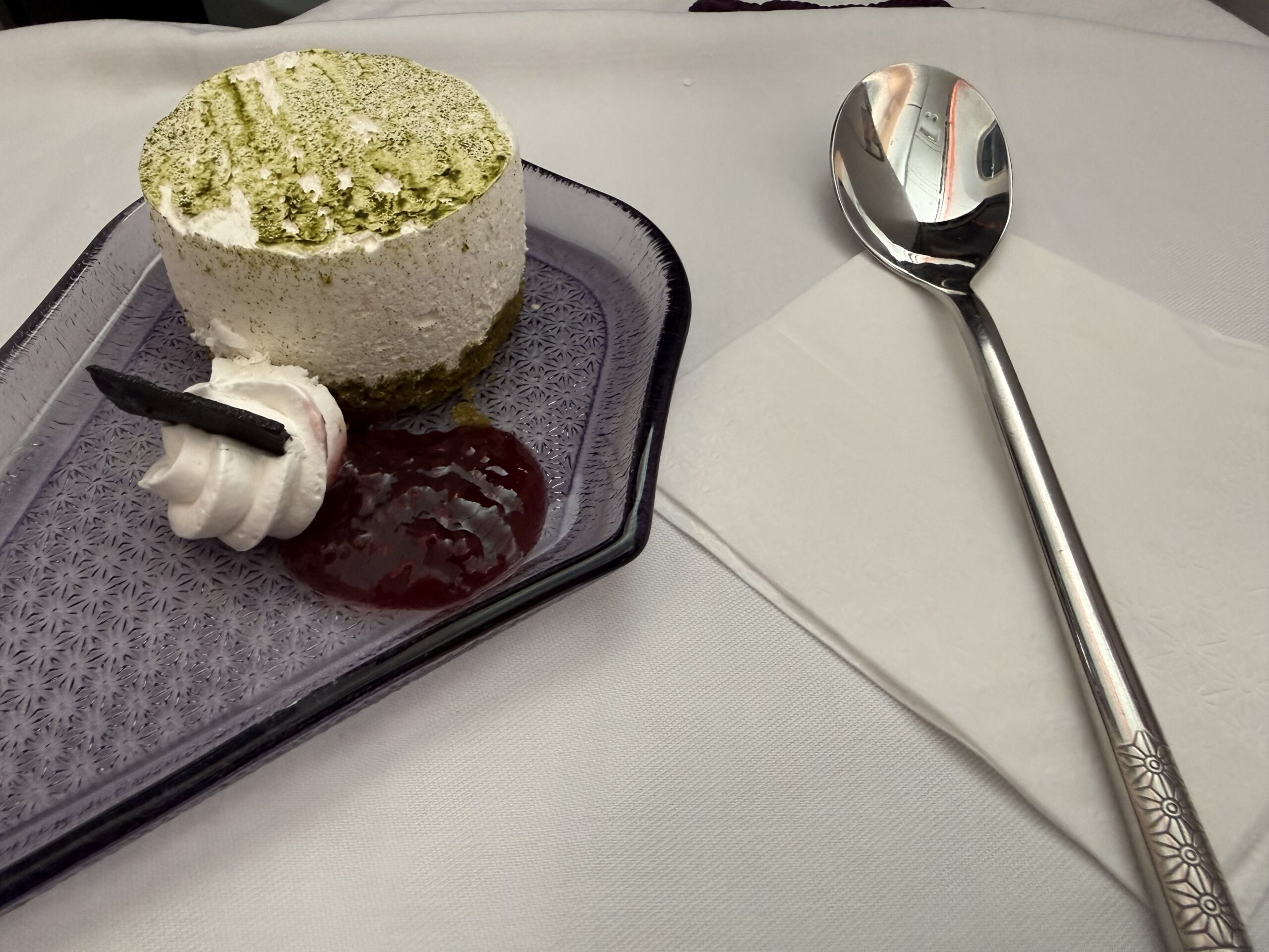 Air India 787-9 Business Class a plate of dessert with a spoon and a napkin