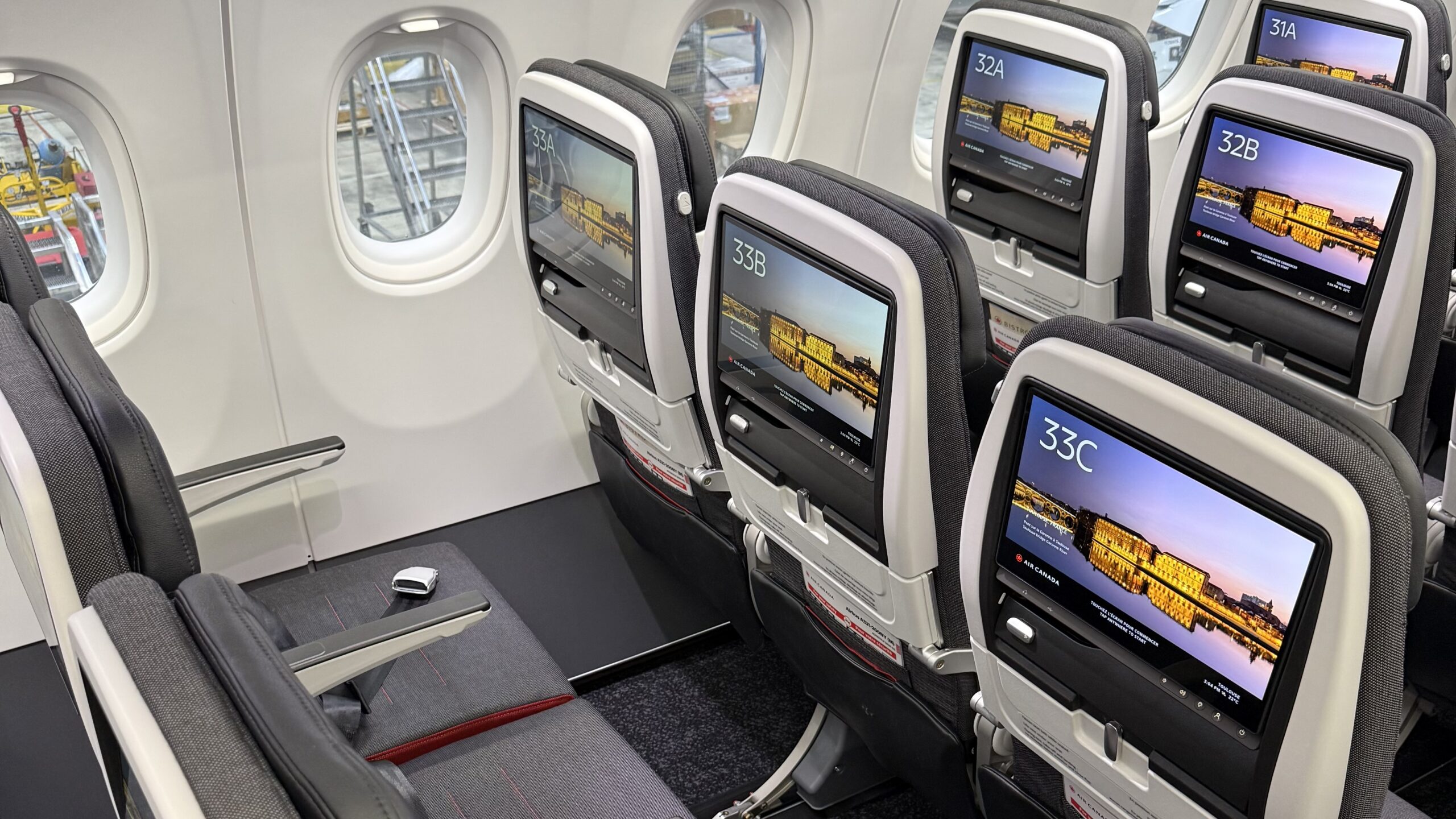 a row of seats with monitors on the side