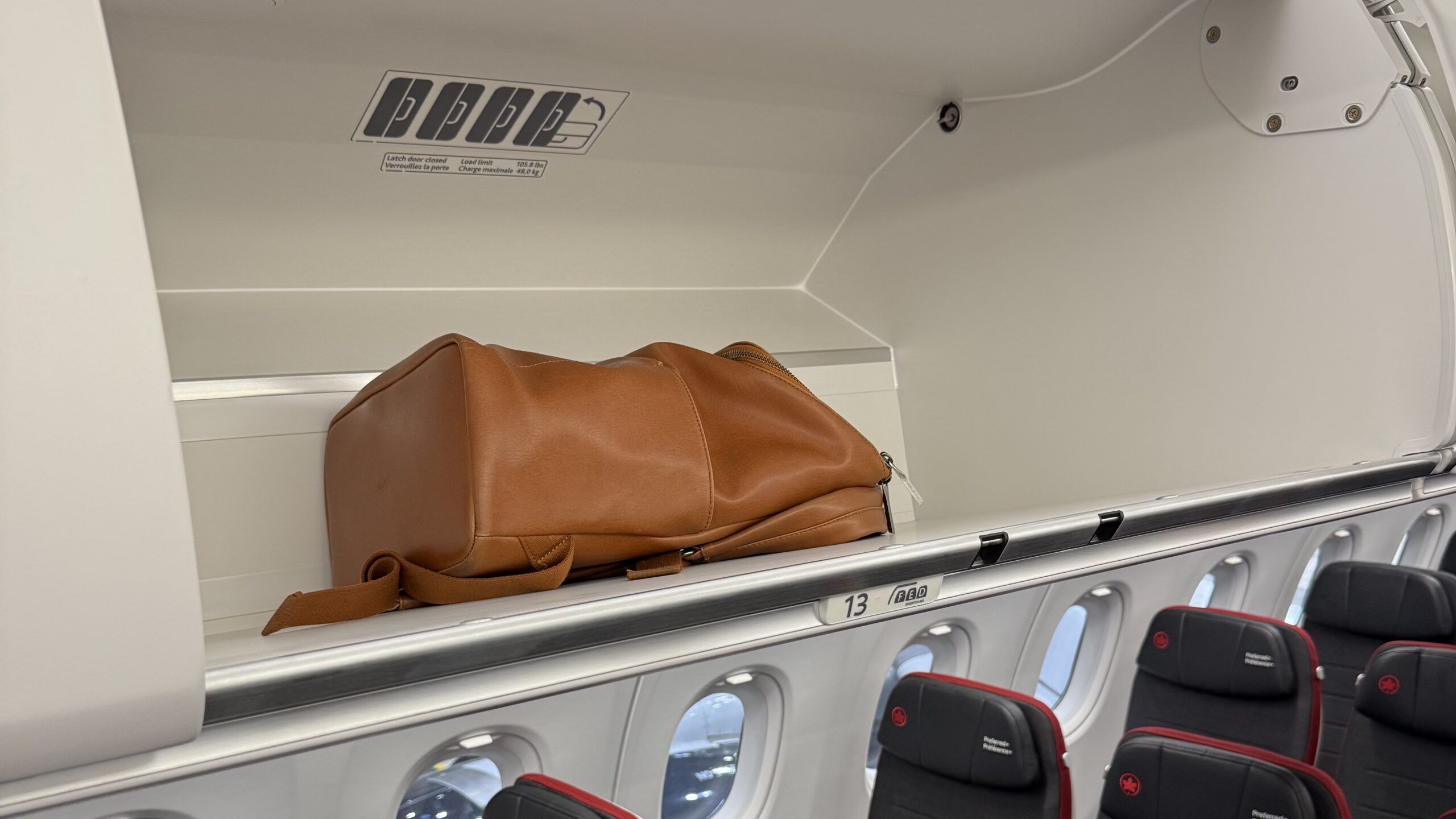 a brown bag on a shelf in an airplane