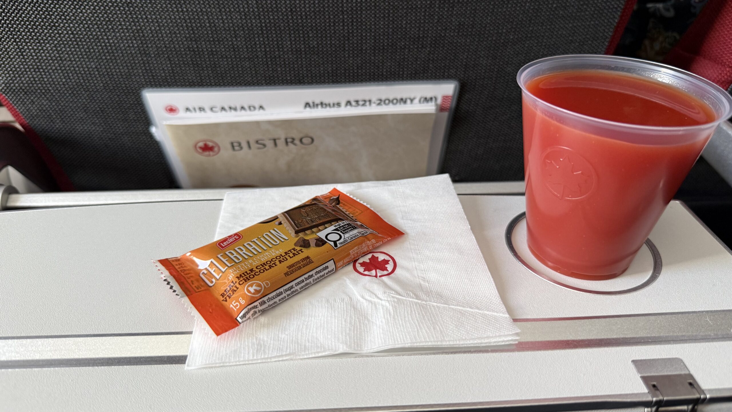 Inaugural Air Canada A321XLR a drink and a package on a napkin