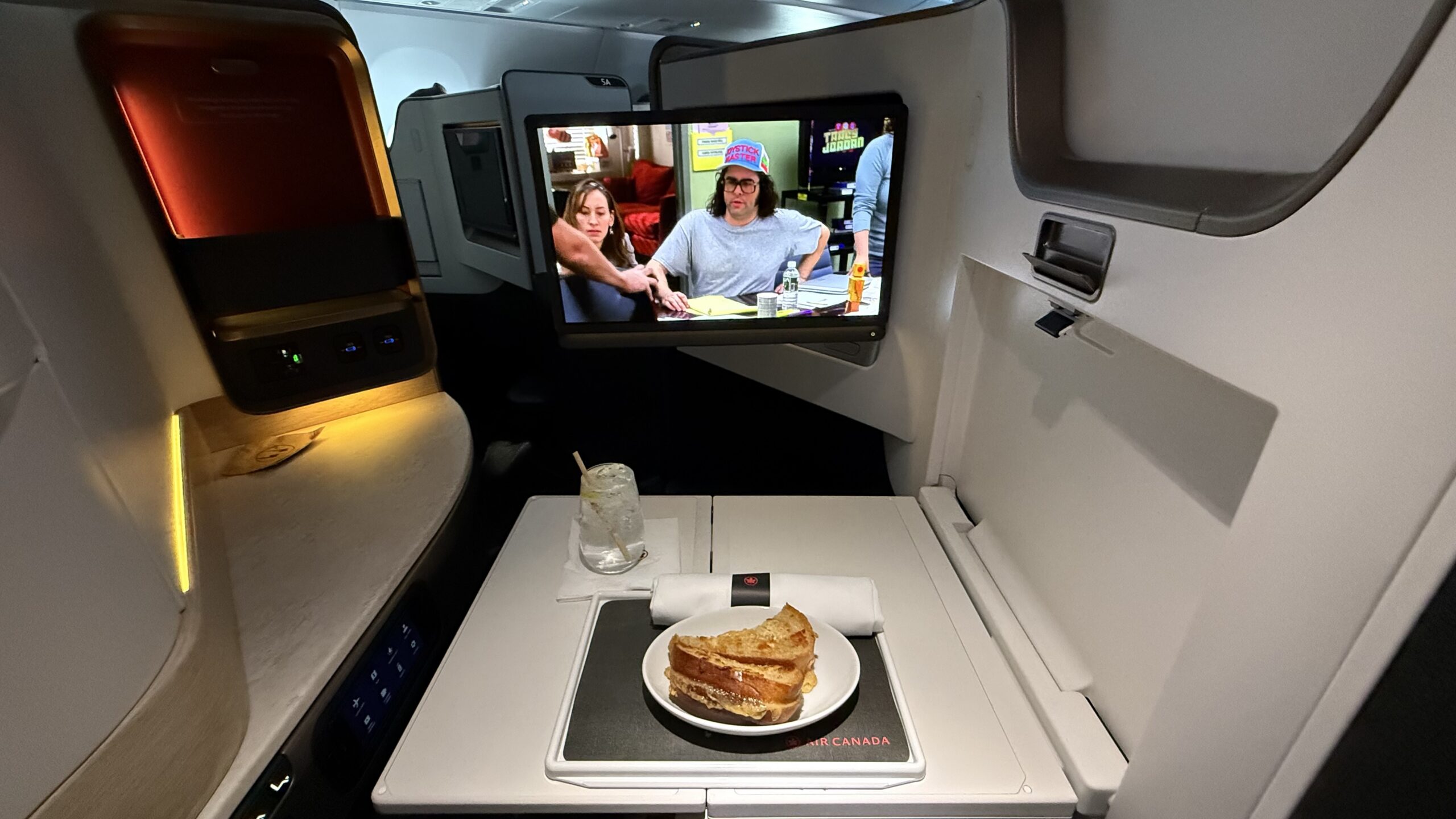 Inaugural Air Canada A321XLR a tv on a table in an airplane