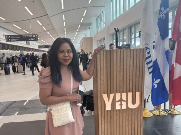 a woman standing next to a wooden sign