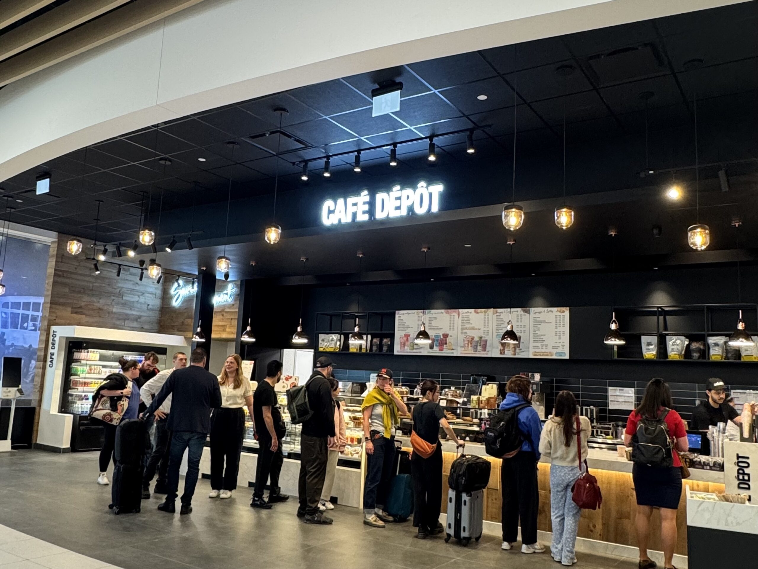 a group of people standing in a line in a cafe