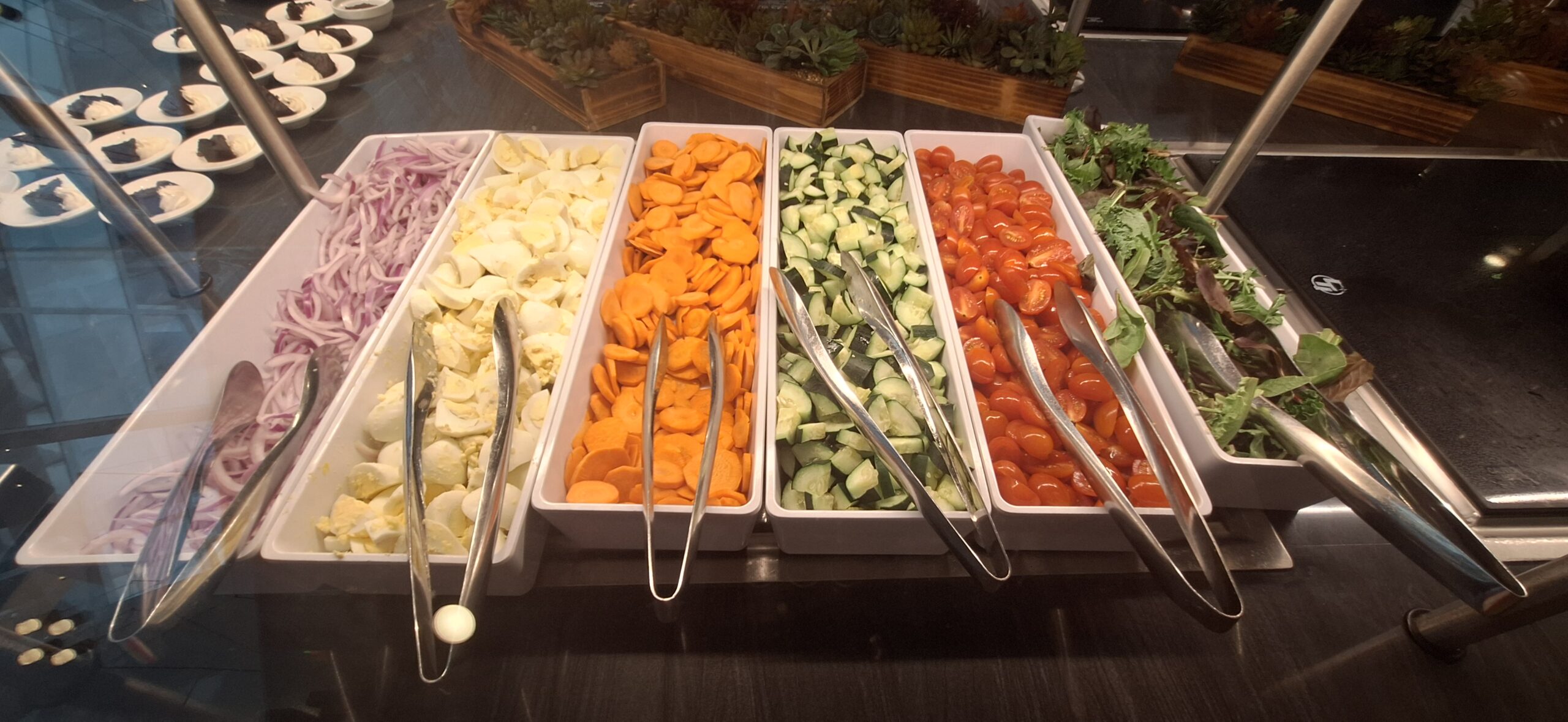 a row of containers with vegetables in them