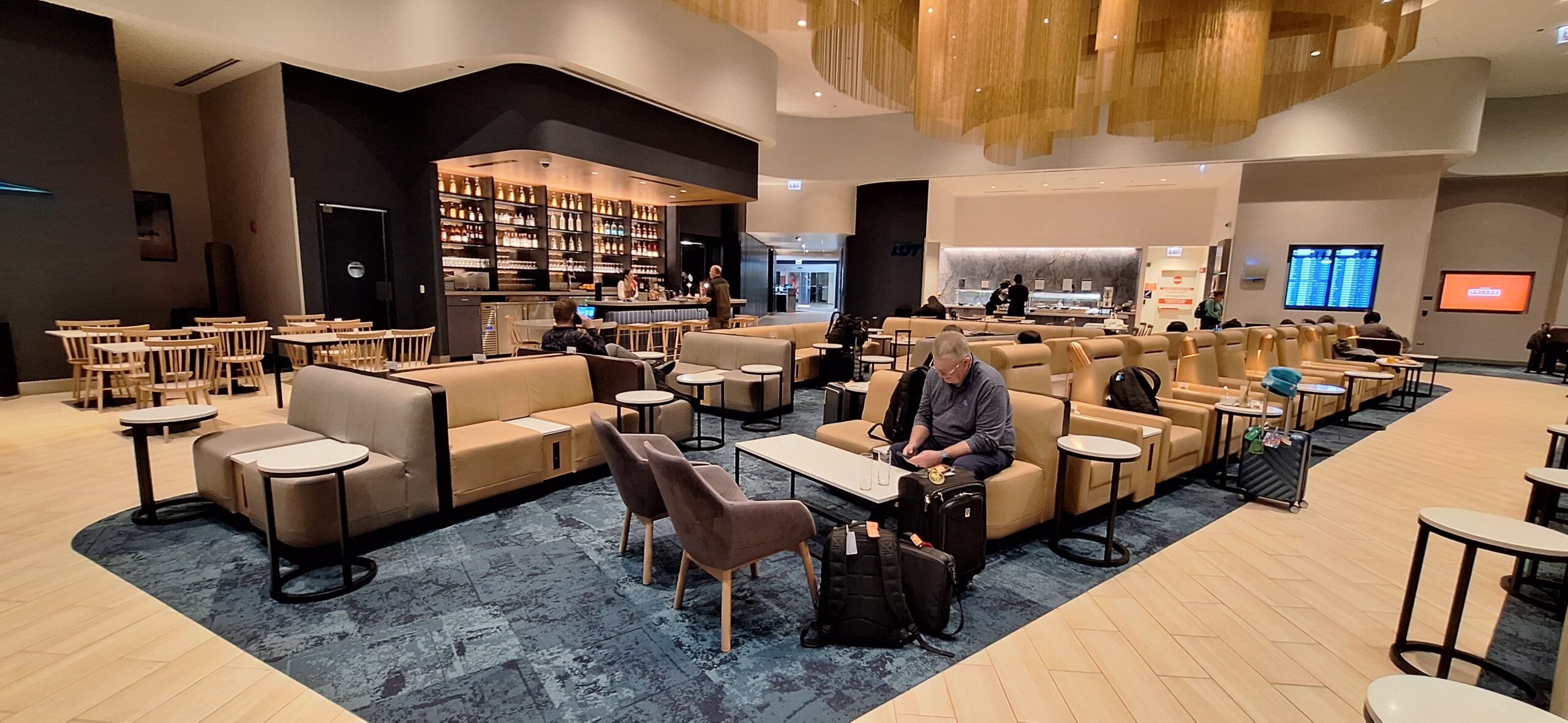 LOT Business Lounge ORD a man sitting in a chair in a lobby
